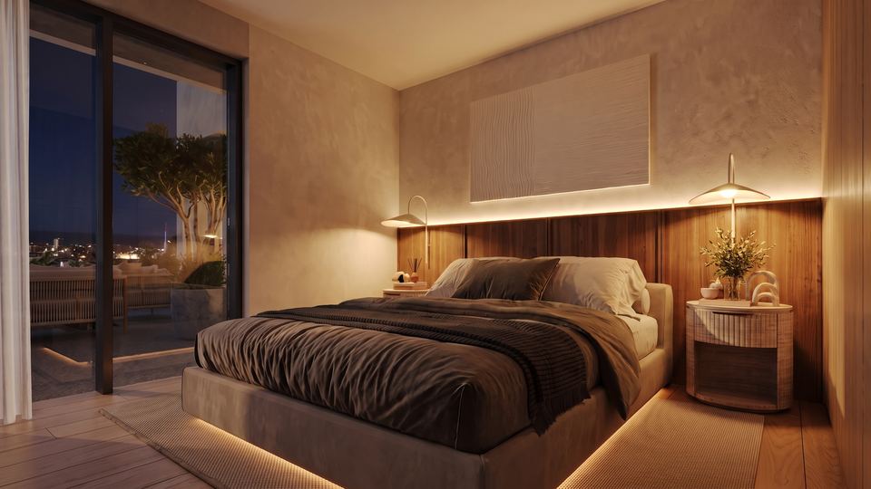Principal bedroom at night with the town lights beyond
